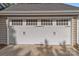White carriage garage door with decorative handles, windows, and concrete driveway at 319 N Central Ave, Locust, NC 28097