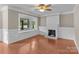 Bright living room with a bay window and classic fireplace, showcasing hardwood floors at 319 N Central Ave, Locust, NC 28097