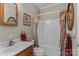 Standard bathroom featuring a sink, toilet, bathtub, and shower with floral patterned shower curtains at 34843 Ellis Spring Ct, Albemarle, NC 28001
