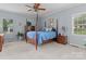 Bedroom featuring a king bed, soft carpet, and dual windows providing natural light at 34843 Ellis Spring Ct, Albemarle, NC 28001