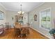 Elegant dining room with hardwood floors, a classic chandelier, and a traditional wooden table set at 34843 Ellis Spring Ct, Albemarle, NC 28001