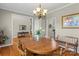 Cozy dining area with hardwood floors, a wooden table set, and views into other living spaces at 34843 Ellis Spring Ct, Albemarle, NC 28001