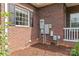 Brick home exterior showcasing electrical panels and a neatly mulched garden bed at 34843 Ellis Spring Ct, Albemarle, NC 28001