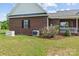 Brick home exterior featuring a generator, AC unit, manicured garden and lush green lawn at 34843 Ellis Spring Ct, Albemarle, NC 28001