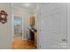Hallway leading to an office space with natural lighting and wood floors at 34843 Ellis Spring Ct, Albemarle, NC 28001