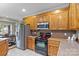 This kitchen features wooden cabinets, stainless steel appliances, and an adjacent dining area at 34843 Ellis Spring Ct, Albemarle, NC 28001