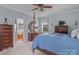 Bright main bedroom with traditional four-poster bed, ceiling fan, and connecting bathroom at 34843 Ellis Spring Ct, Albemarle, NC 28001