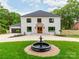 Elegant two-story white brick home featuring a well-manicured lawn and a charming fountain at 3501 Providence Rd, Charlotte, NC 28211