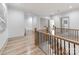 Bright hallway with light wood floors, neutral paint, and wood and black iron railing overlooking the staircase at 3501 Providence Rd, Charlotte, NC 28211