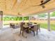 Covered outdoor patio area with ceiling fans, wood ceiling, tile flooring, and seating arrangement at 3501 Providence Rd, Charlotte, NC 28211