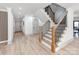 Bright foyer features staircase with wood and black iron railing, light wood floors, and neutral paint at 3501 Providence Rd, Charlotte, NC 28211