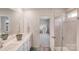 Bright bathroom with double sinks, a walk-in shower, and a doorway leading to a bedroom at 356 Runner Stone Ln, Fort Mill, SC 29715