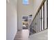 Bright entryway hallway with wood floors, staircase, and front door view at 356 Runner Stone Ln, Fort Mill, SC 29715