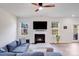 Bright living room featuring a fireplace, large TV, ceiling fan, and comfortable blue sofa at 356 Runner Stone Ln, Fort Mill, SC 29715