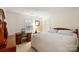 Cozy bedroom featuring wood furniture, a white patterned quilt, and bright natural light at 3604 Braefield Dr, Indian Trail, NC 28079