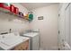 Functional laundry area with a washer, dryer, shelving, and a bright overhead light at 3604 Braefield Dr, Indian Trail, NC 28079
