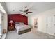 Main bedroom with a bay window, ceiling fan and red accent wall at 3604 Braefield Dr, Indian Trail, NC 28079