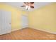 Comfortable bedroom with hardwood floors, ceiling fan, large window, and closet at 3951 Jasmine Ln, Denver, NC 28037