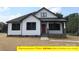 Stunning white home design boasting a covered front porch and dark window frames at 408 N Peterson St, Stanley, NC 28164