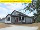 Beautifully constructed white home featuring a covered front porch and an inviting red door at 408 N Peterson St, Stanley, NC 28164