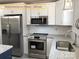 This updated kitchen has white cabinets, granite countertops, and stainless steel appliances at 408 N Peterson St, Stanley, NC 28164