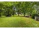 Spacious backyard featuring lush greenery, mature trees, a shed, and a trailer at 430 Sells Rd, Salisbury, NC 28144