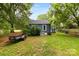 Home's backyard showing mature trees, a trailer, and the rear of the house at 430 Sells Rd, Salisbury, NC 28144