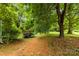 View of a large backyard with mature trees, grass, and a trailer at 430 Sells Rd, Salisbury, NC 28144