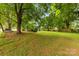 Wide backyard with mature trees and grass and small shed at 430 Sells Rd, Salisbury, NC 28144
