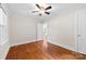 Bright bedroom featuring hardwood floors, white trim, ceiling fan, and a doorway that leads to another room at 430 Sells Rd, Salisbury, NC 28144