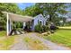 Charming blue home with attached carport, lush landscaping, and a gravel driveway at 430 Sells Rd, Salisbury, NC 28144