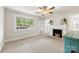 Spacious living room with a vintage ceiling fan, large window, and decorative fireplace at 430 Sells Rd, Salisbury, NC 28144
