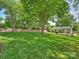 Well-maintained backyard with green lawn, mature trees, and a deck with outdoor seating at 4921 Doris Ave, Charlotte, NC 28205