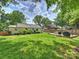 Lush backyard with green lawn, mature trees, and a deck with outdoor seating at 4921 Doris Ave, Charlotte, NC 28205