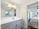 Bright bathroom with a large vanity, modern lighting, and a view into a bedroom at 4921 Doris Ave, Charlotte, NC 28205