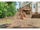 Exterior image of backyard showing wooden staircase leading to upper deck and grassy, partially wooded yard at 5022 Saybrook Dr, Harrisburg, NC 28075