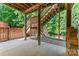 View of a covered basement patio area with wooden support columns and stairs leading to upper yard at 5022 Saybrook Dr, Harrisburg, NC 28075