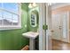Bathroom features a pedestal sink, an oval mirror, decorative fixtures, and a large window at 5022 Saybrook Dr, Harrisburg, NC 28075