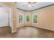 Bright bedroom featuring hardwood floors, a ceiling fan, and a view of trees at 5022 Saybrook Dr, Harrisburg, NC 28075