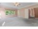 Spacious main bedroom featuring a ceiling fan, a large window with natural light, and neutral-toned carpet at 5022 Saybrook Dr, Harrisburg, NC 28075