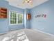 Bright bedroom with a ceiling fan, a large window with natural light, and light blue-painted walls at 5022 Saybrook Dr, Harrisburg, NC 28075