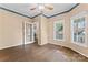 Bright bedroom featuring hardwood floors, a ceiling fan, and a view of trees at 5022 Saybrook Dr, Harrisburg, NC 28075