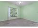 Bright bedroom with large window, neutral carpet, ceiling fan and light green walls at 5022 Saybrook Dr, Harrisburg, NC 28075