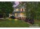 Charming two-story home featuring a covered front porch with classic white columns and well-manicured lawn at 5022 Saybrook Dr, Harrisburg, NC 28075