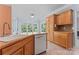 Kitchen featuring wooden cabinets, stainless steel dishwasher, and eat-in island at 5022 Saybrook Dr, Harrisburg, NC 28075