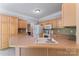Bright kitchen features light wood cabinetry, modern appliances, spacious countertop, and ample storage space at 5022 Saybrook Dr, Harrisburg, NC 28075
