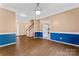 Spacious living room with hardwood floors, blue and tan walls, and access to the staircase and kitchen at 5022 Saybrook Dr, Harrisburg, NC 28075