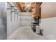 Unfinished basement storage area with shelves and utility hookups at 5022 Saybrook Dr, Harrisburg, NC 28075