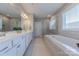 Bathroom featuring double sinks, soaking tub, and glass enclosed shower for a luxurious experience at 5128 Oakhaven Ln, Fort Mill, SC 29708