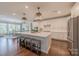 Bright kitchen features a large center island with seating, modern appliances and stylish pendant lighting at 5128 Oakhaven Ln, Fort Mill, SC 29708